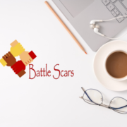Battle Scars logo next to cup of coffee and laptop