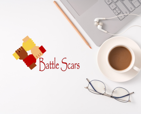 Battle Scars logo next to cup of coffee and laptop